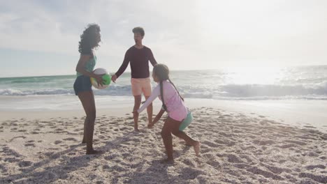 Happy-hispanic-mother,-father,-son-and-daughter-playing-with-ball-on-beach