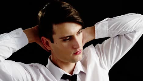 androgynous man posing against black background