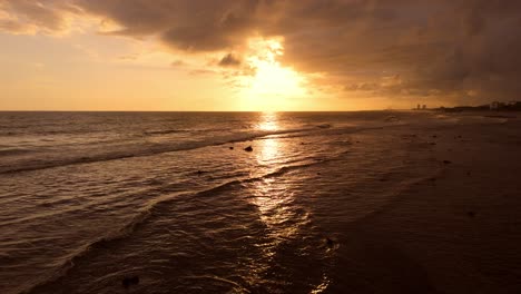 drone flying at low altitude over shallow sea waters during golden hour, juan dolio in dominican republic