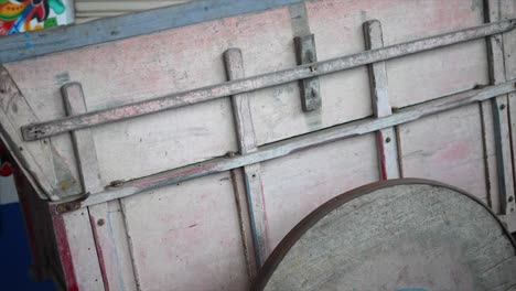 close-up of an old, rustic wooden cart wheel and frame