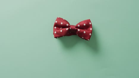 Video-of-red-dotted-bow-tie-lying-on-green-background