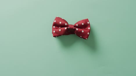 video de una corbata de pajarita con puntos rojos sobre un fondo verde
