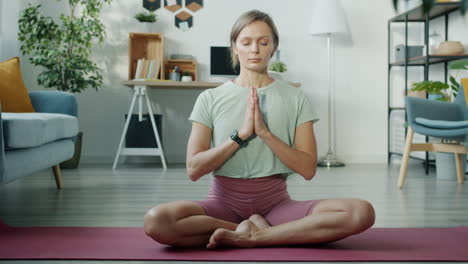 woman meditating in a home living room