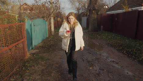 woman walking down a country road in autumn