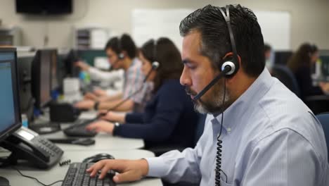 a focused team in a call center: professionals engaging in customer support and technical assistance with headsets and computers