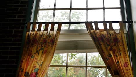 a decorative window with floral yellow curtains