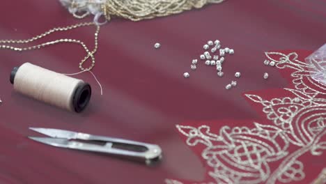 closeup of textiles and beads used by a tailor to manufacture a sari, traditional bridal dress in pakistan