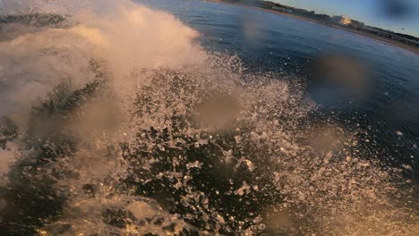 surfer breaking waves on a carcavelos surf spot in lisbon during amazing sunrise