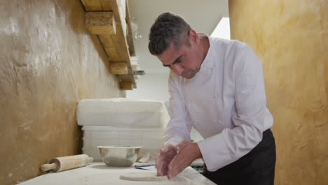 caucasian man making a pizza dough