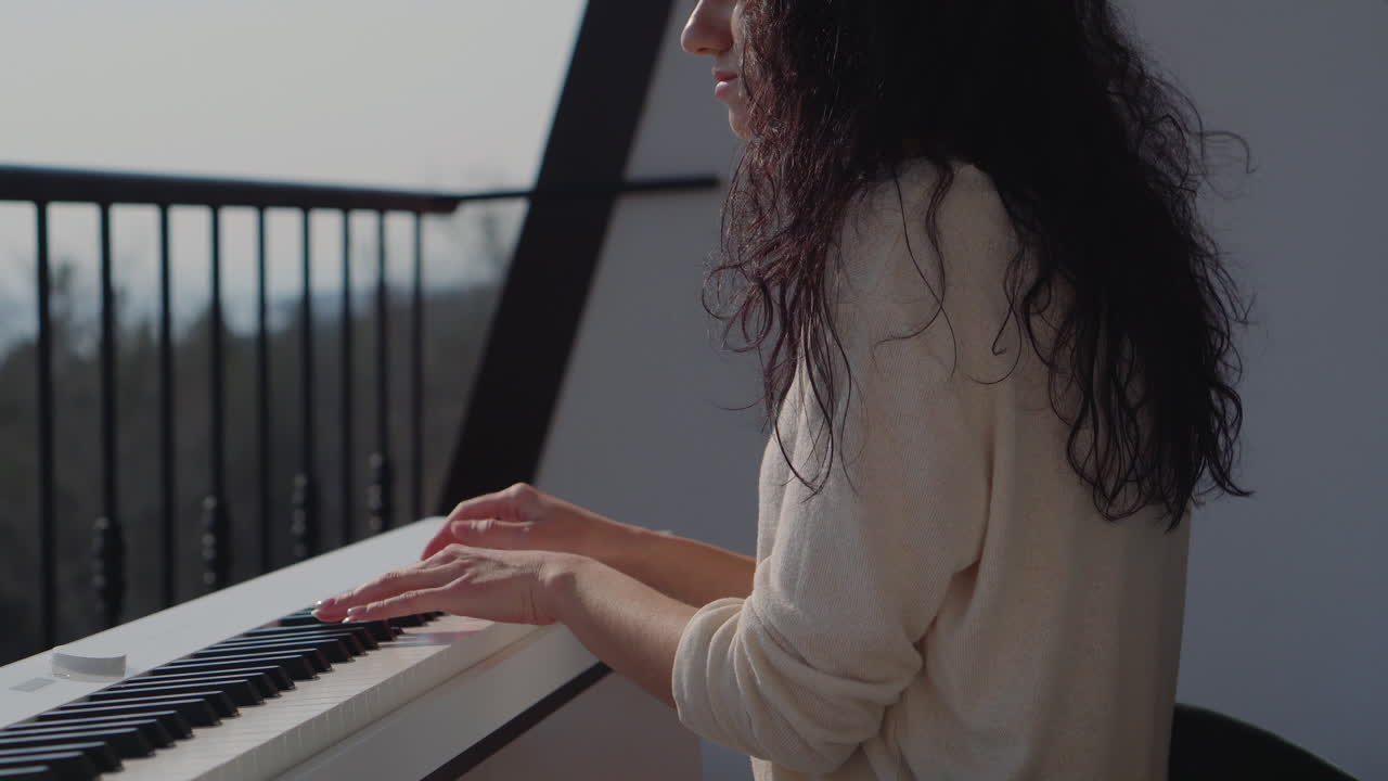 mujer tocando el piano en un balcón con una vista