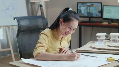 asian woman engineer with a laptop drawing blueprint at the office
