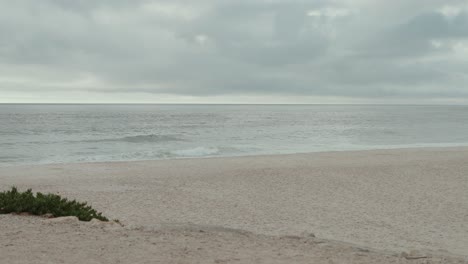 calm sea meets quiet sandy shore on a cloudy peaceful morning