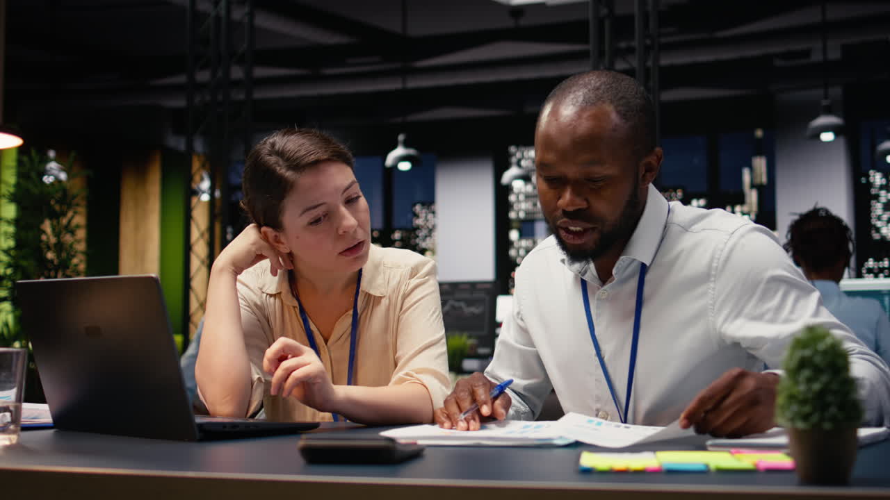 Diverse coworkers on laptop managing tasks and documenting project progress