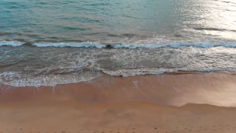 waves crashing on a sandy beach in algarve