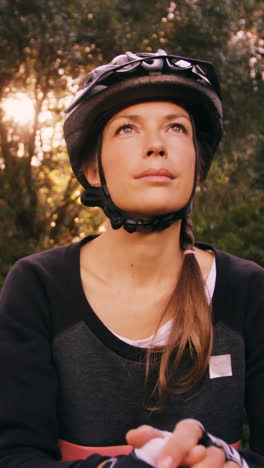 female mountain biker standing with bicycle looking up