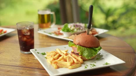 hamburger con patatine e bibite analcoliche, accanto al ceviche
