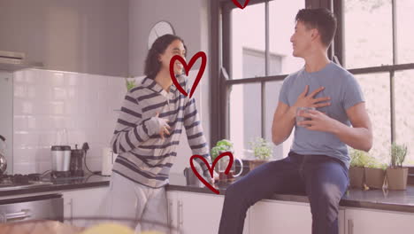 animación de corazones rojos sobre feliz pareja de hombres homosexuales diversos hablando y riendo en la cocina