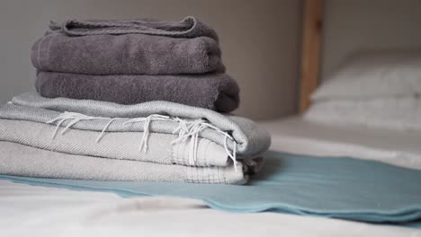 folded towels and blankets on a bed