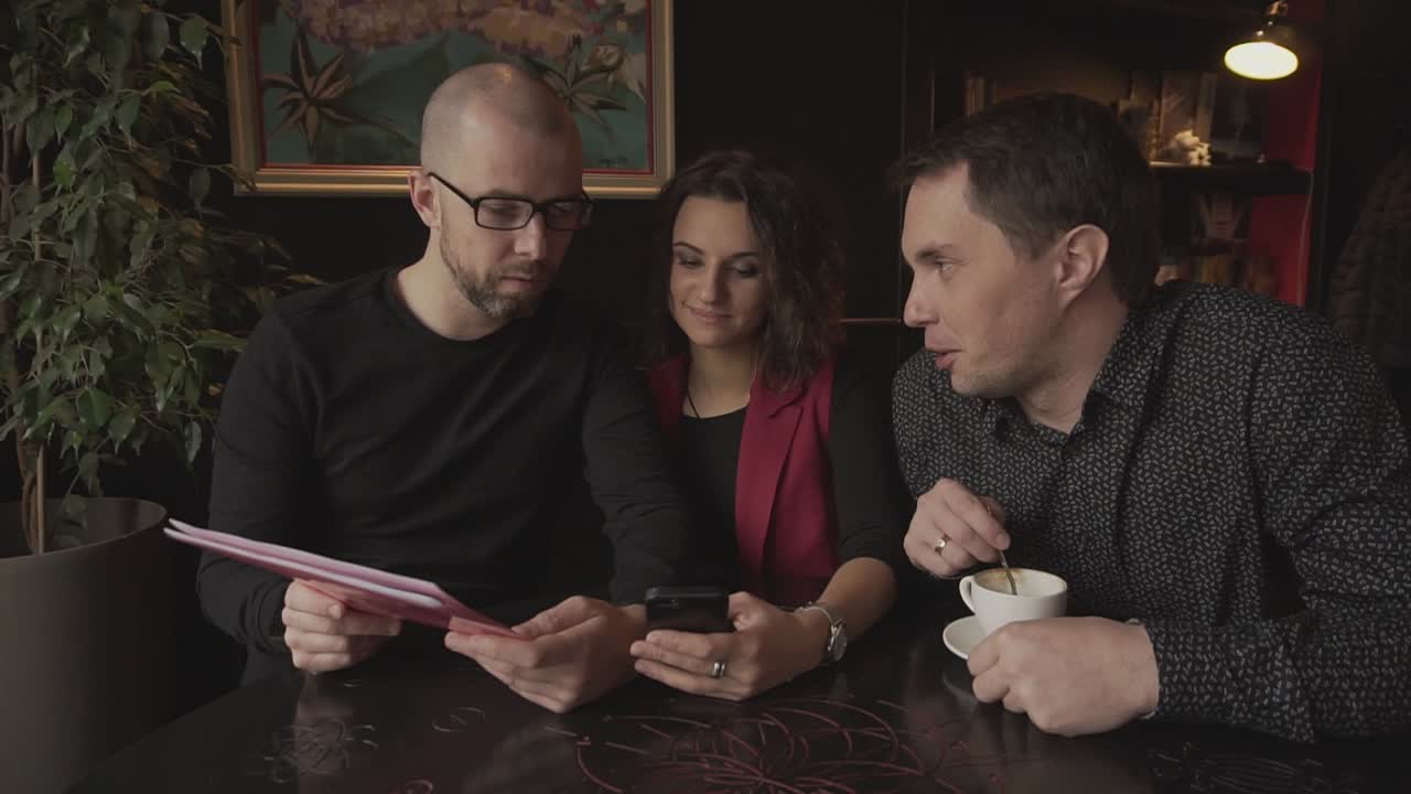 People discussing documents in a cafe
