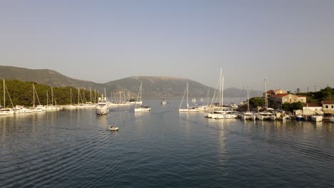 scenic summer sunset evening in coastal city fiskardo, greece, aerial dolly in