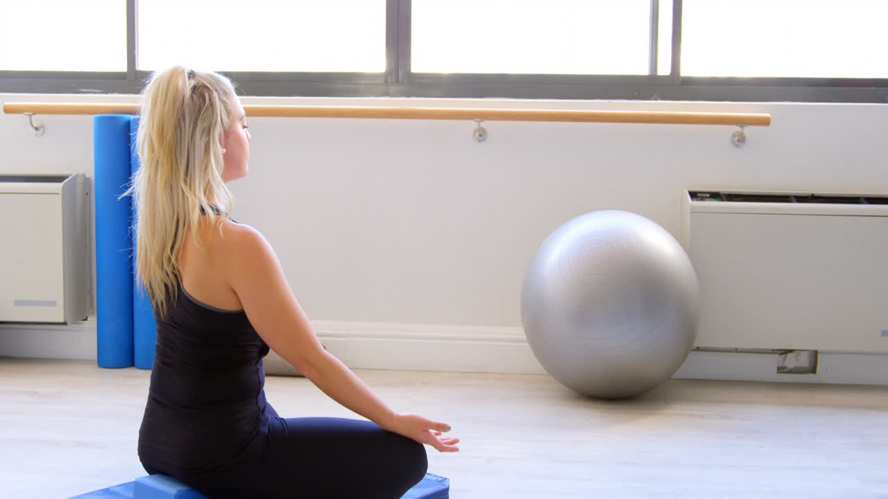 Woman doing yoga in fitness gym 4k