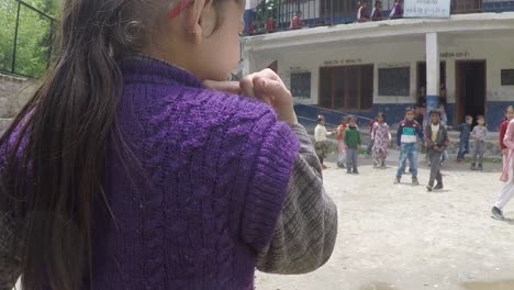 manali, india, circa 2019 - young children play tag at a village school in the himalayas_1