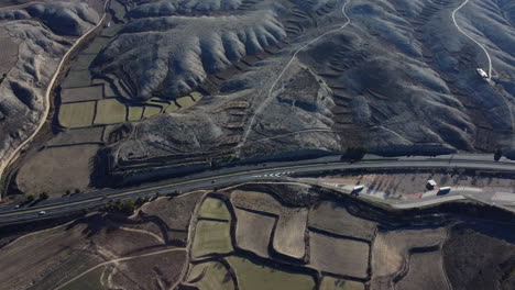 aerial view of a highway and terraced fields in a mountainous landscape