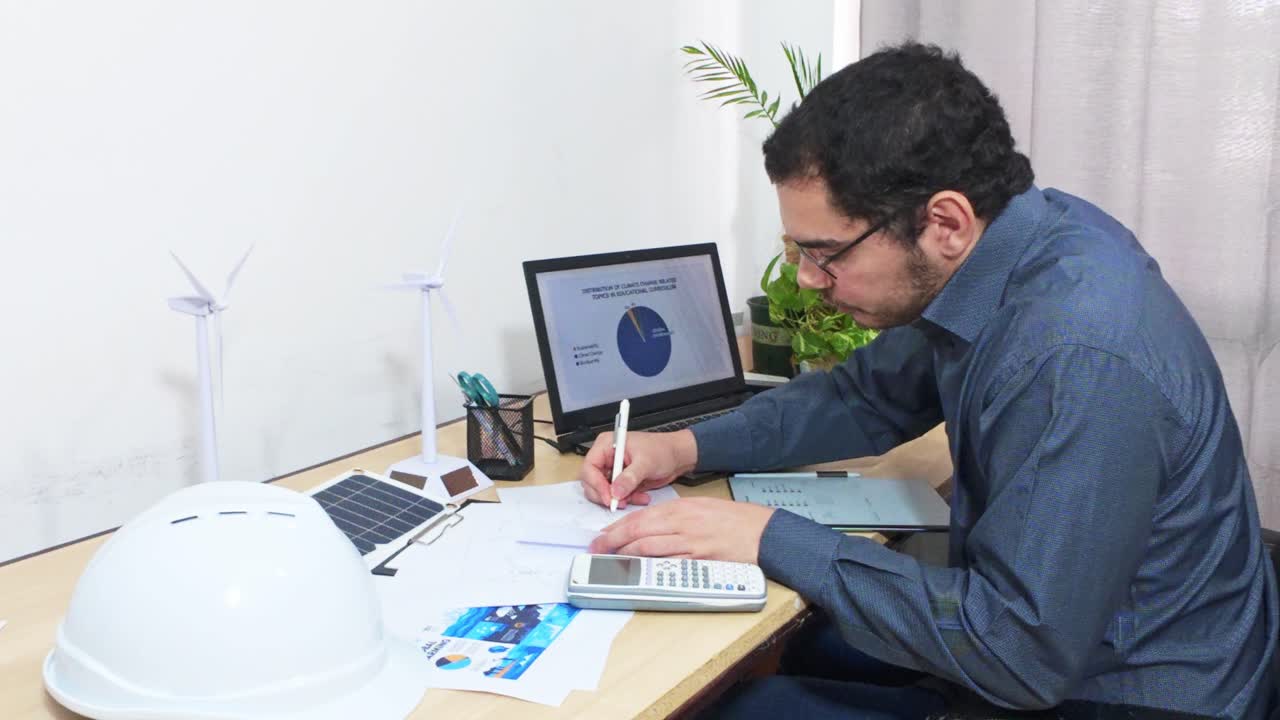 Engineer Making Corrections on a Wind Turbine Blueprint