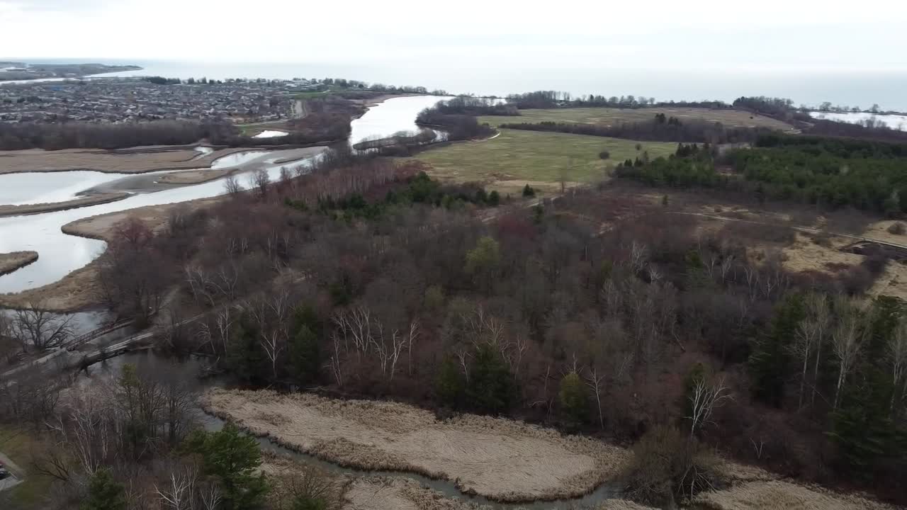 drone dando vueltas sobre campos de invierno cerca de un río congelado en ajax