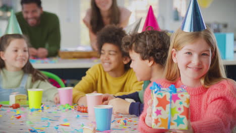 chica dando regalos en una fiesta de cumpleaños con amigos y padres en casa