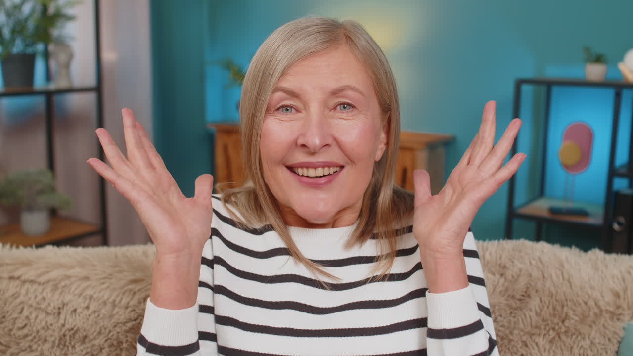 Excited mature woman surprised shocked by sudden victory good win news celebrating wow reaction
