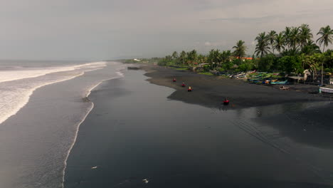 Along-wet-sandy-beach-riders-travel-at-speed-on-quad-bikes