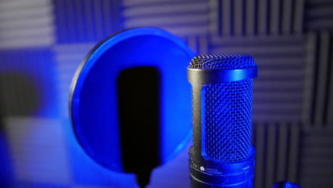 close up of a condenser capacitor microphone in a voice-over podcast vocal booth in a recording studio