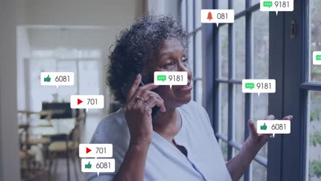 Animation-Von-Social-Media-Benachrichtigungen-über-Eine-Frau,-Die-Am-Fenster-Telefoniert