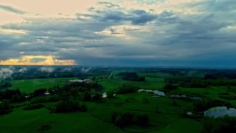 Aerial-time-lapse-sun-behind-moving-clouds-over-green-rural-landscape