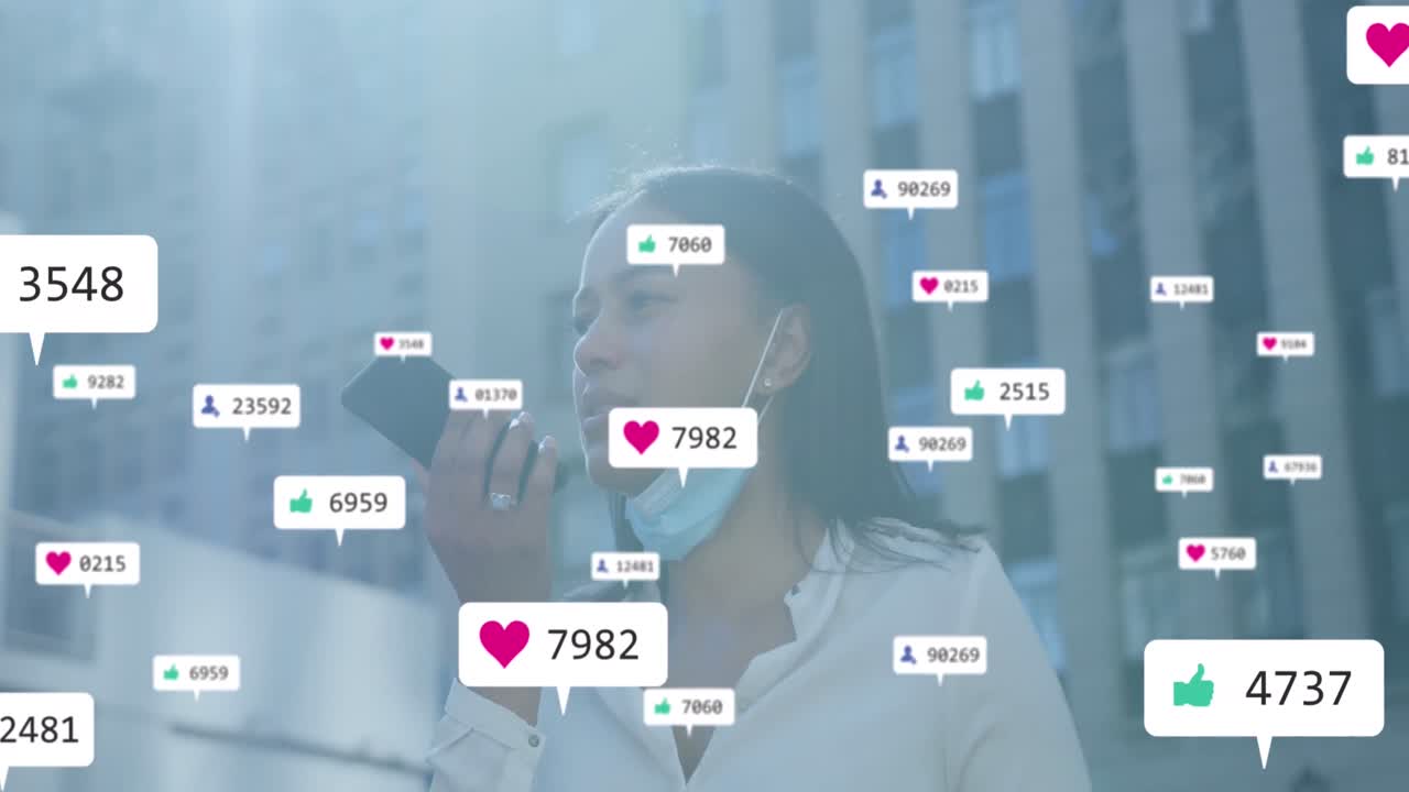 A black woman is talking on her smartphone and wearing a face mask while walking in a city street