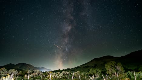 milky way time lapse over an old fence and mountains in the utah west desert