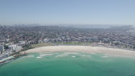 Panorama-Des-überfüllten-Bondi-Beach-Mit-Dunstigem-Nebel,-Während-Nebel-über-Einen-Vorort-In-Sydney,-New-South-Wales,-Rollt