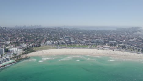 panorama of crowded bondi beach with hazy mist as fog rolls over suburb in sydney, new south wales