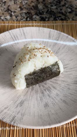 Stuffed Rice Onigiri With Nori Seaweed On A Plate - Close Up, Vertical Shot