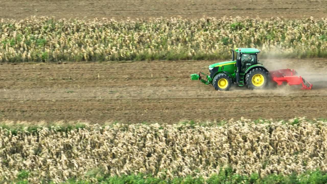 tractor moderno tirando de arado de disco viejo y arando