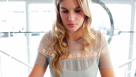 Hermosa-Mujer-Usando-Laptop-Mientras-Toma-Café