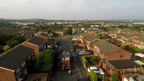 aerial view, footage of dustmen putting recycling waste into a garbage truck, bin men, refuse collectors