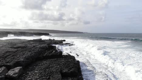 Aerial-of-stormy-irish-coastline-with-big-waves-hitting-dark-cliffs