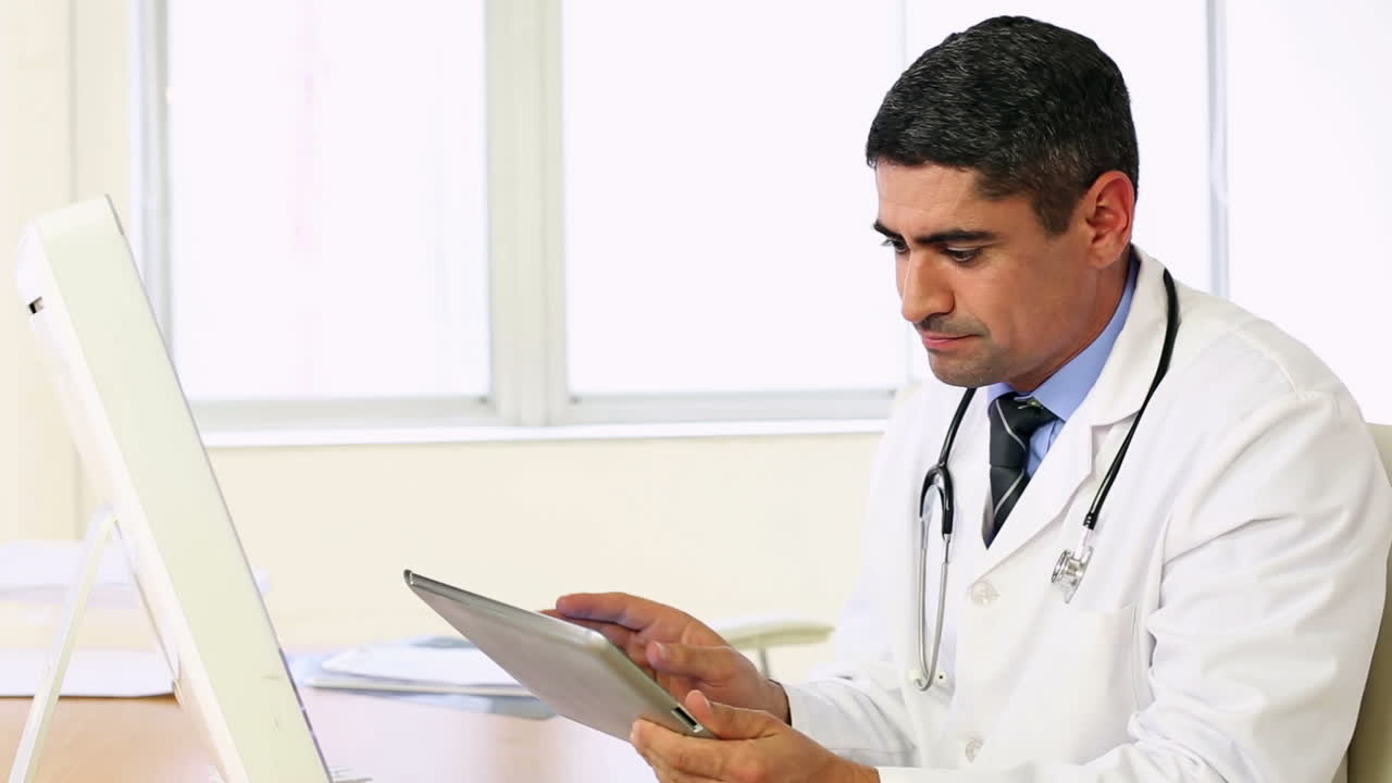 Doctor working at his desk with tablet pc