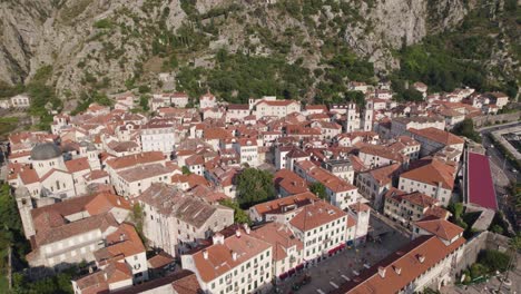 aerial: kotor, montenegro con edificios históricos y un telón de fondo montañoso