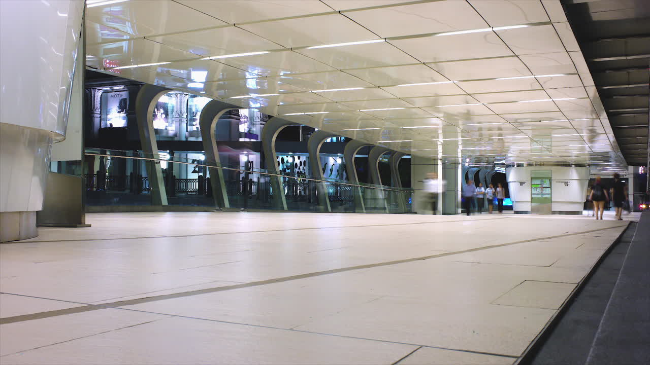 un lapso de tiempo de gente de negocios ocupada, multitud y peatones anónimos en la pasarela de varios niveles que conecta centros comerciales y edificios de oficinas en un paisaje urbano urbano