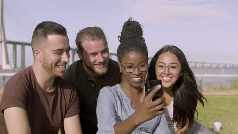 Happy-friends-taking-selfie-with-smartphone-at-park