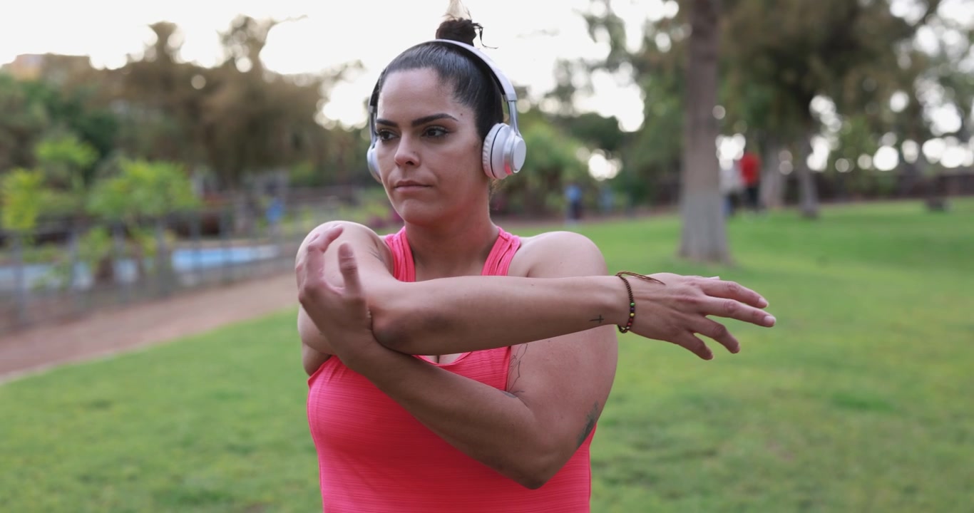 Woman Stretching Arms in Park Before Workout