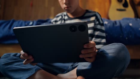 Boy Using Tablet in Bedroom